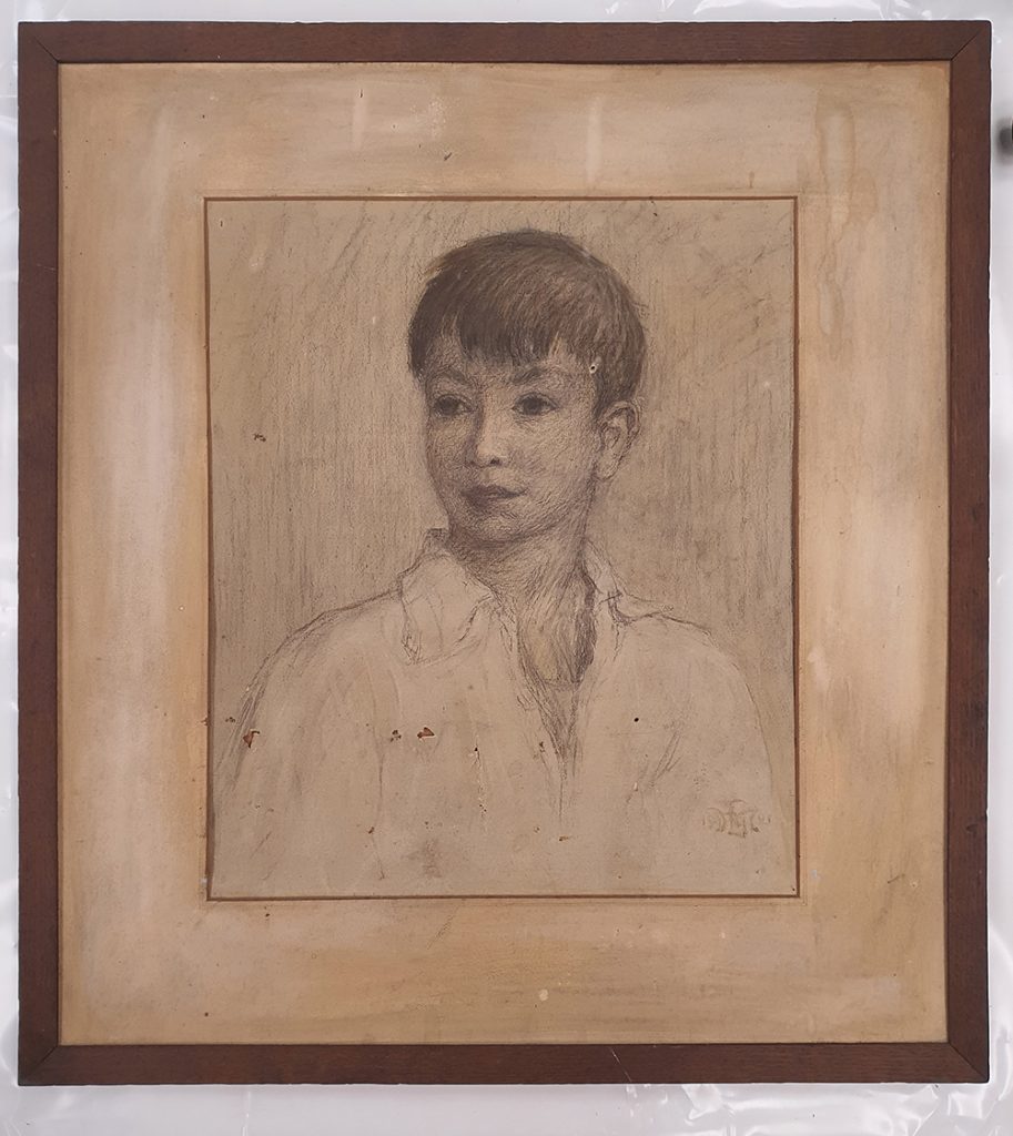 Framed Portrait of a boy approx. 10 years drawn in charcoal, chalk and pastel. There is some visible damage to the artwork including small tears and punctures. The Mount has a mottled / faded appearace.