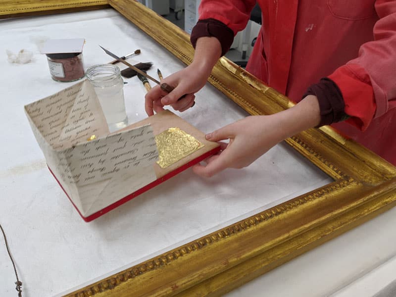 gilding gilt picture frame in the Plowden & Smith gilding studio