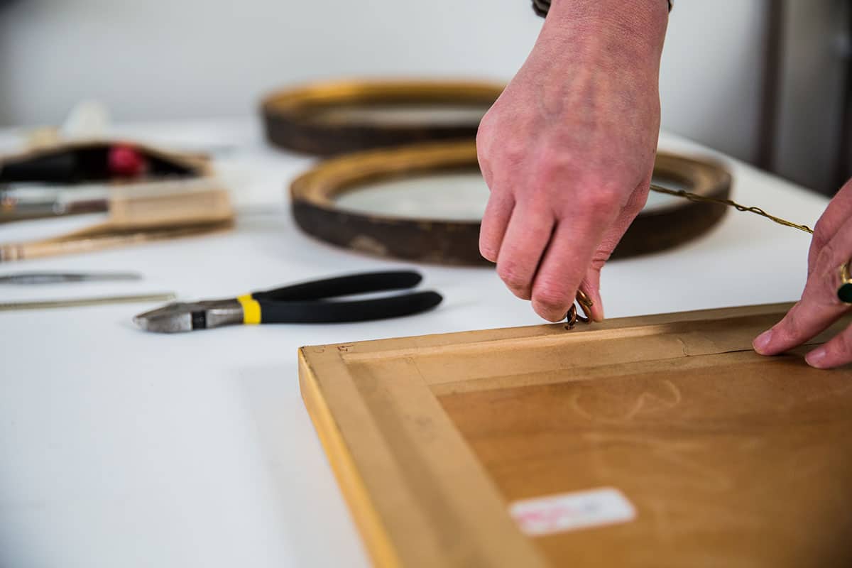 painting restorer conservation framing a painting